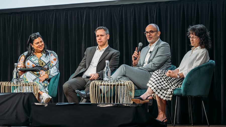 Four panellists in conversation on stage at NEDC