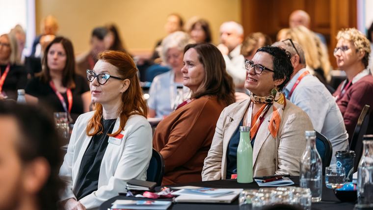 Delegates listening from the front rows of a session